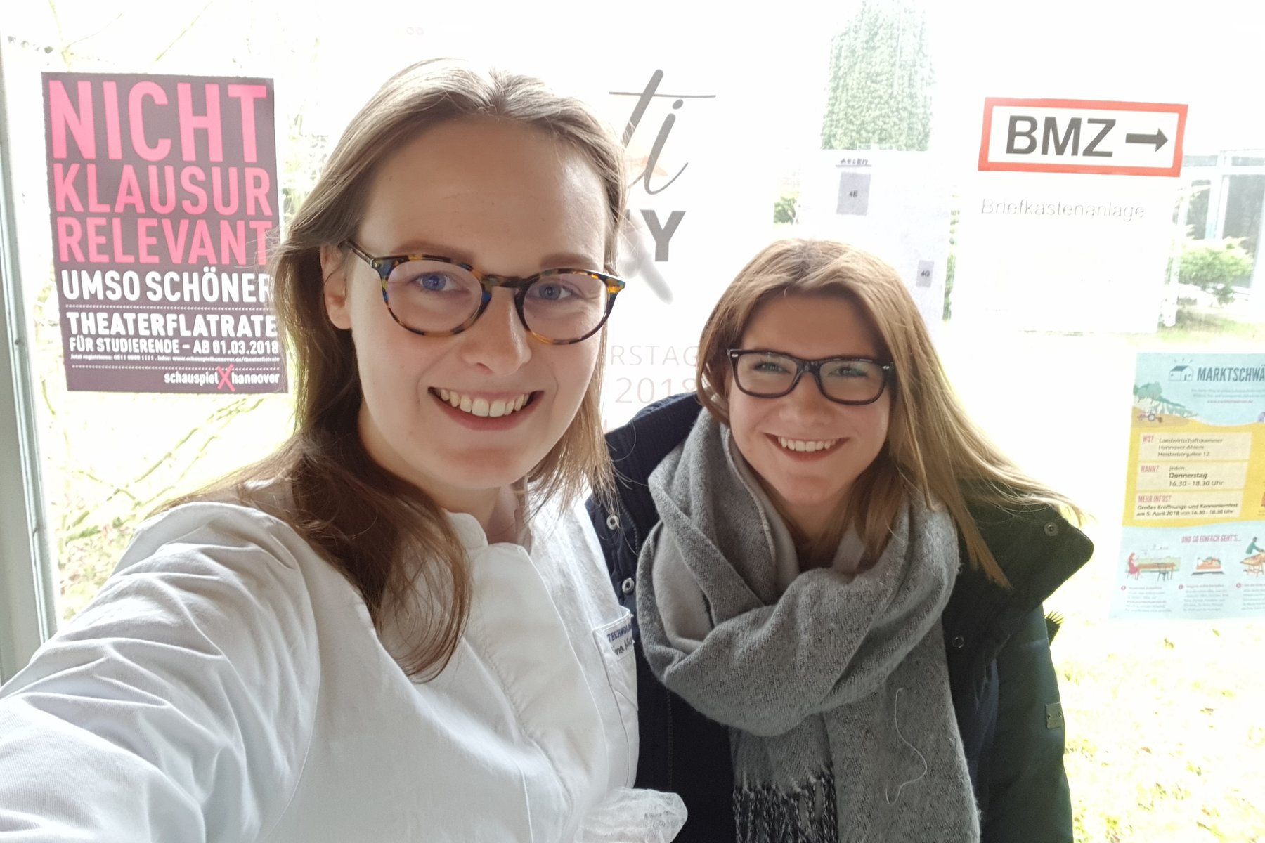 Zwei junge Frauen mit Brille strahlen in ein Selfie